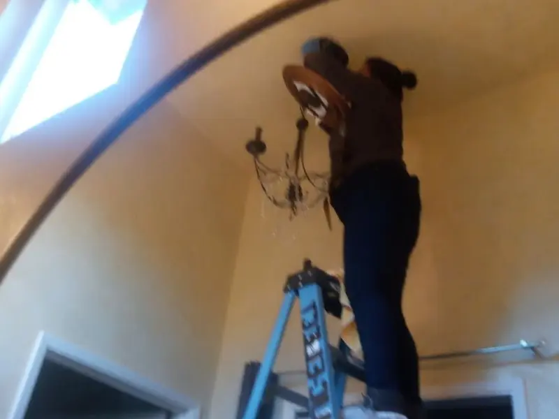 Electrician installing a chandelier in a Milton-Freewater residence